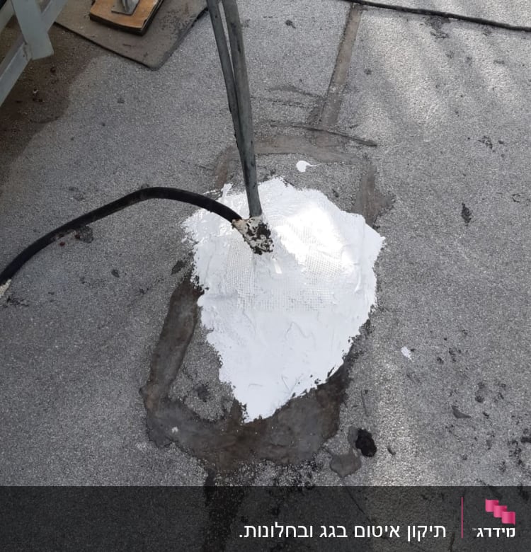 תיקון גג עם חומר איטום לבן סביב צינור.